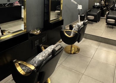 Elegant salon interior at THE BEAUTY BAR GROUP, Durban, Kwazulu-natal, ZA featuring chic black and gold chairs.