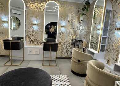 Sophisticated salon at THE BEAUTY BAR GROUP, Durban, Kwazulu-natal, ZA, featuring modern gold accents and elegant mirrors.