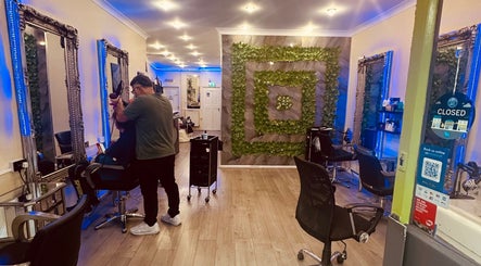 Beautiful salon interior at Vani Beauty, London, England, GB with modern decor and hairstylist working.