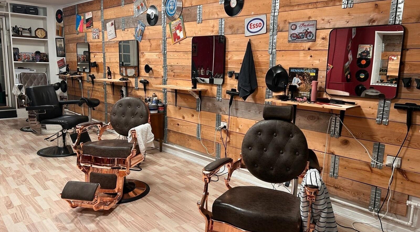 Indretning af Carlsens Barber Academy i Odense, DK med klassiske barberstole og træpanelvægge.