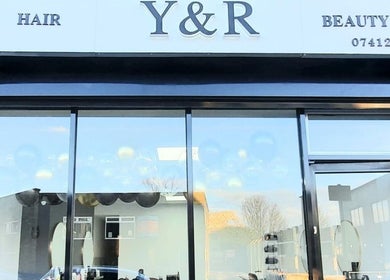 Front view of Y&R Salon, a chic beauty venue in Pudsey, England, GB featuring a sleek glass entrance.