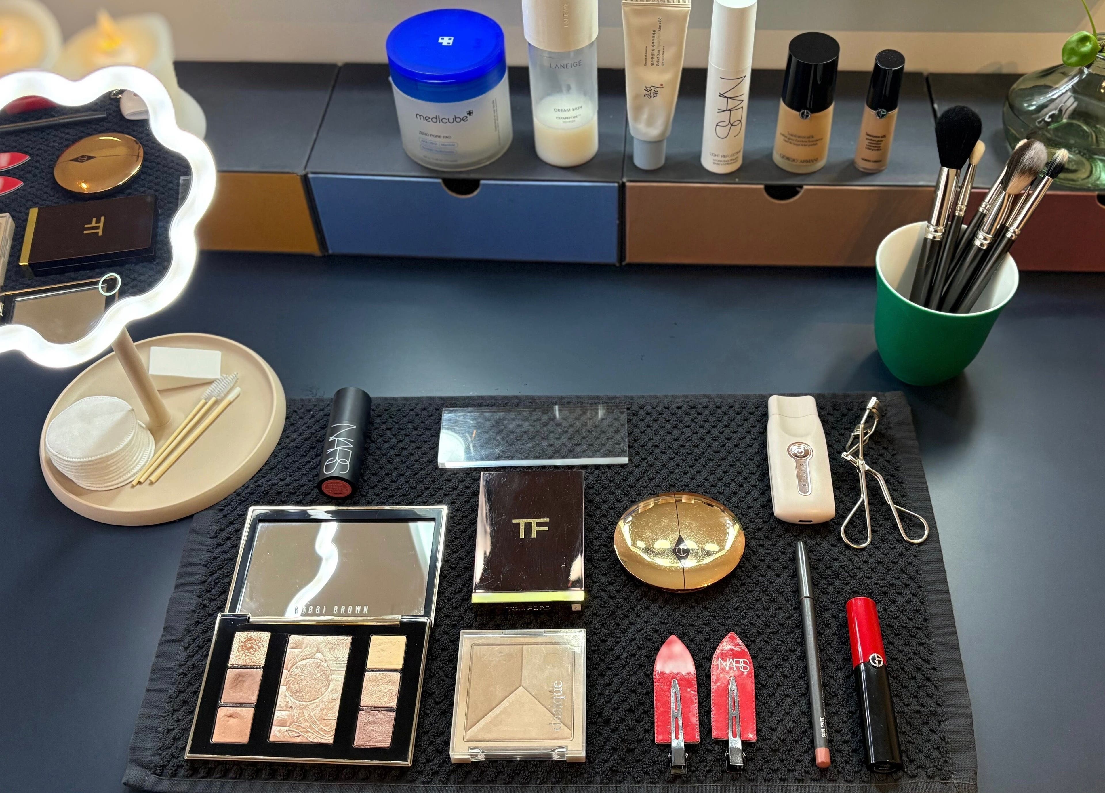 Maria Ovejero Beauty in Kortrijk, Vlaanderen, BE showcases diverse beauty products and tools on a dark countertop.