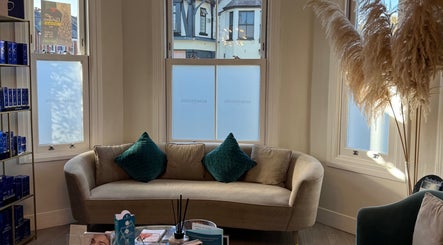 Inviting lounge at Energy Flow Therapy, Hale, England, GB with plush sofa and decorative elements.