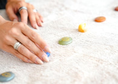 Energy Flow Therapy, Hale, England: Hand arranging polished stones for holistic healing.