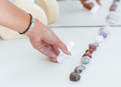 A hand aligns crystals at Energy Flow Therapy, Hale, England, GB, enhancing tranquility and wellness.