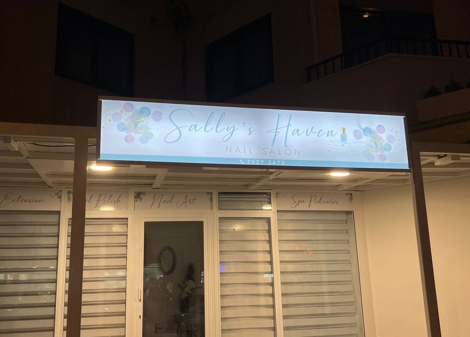 Ingresso del salone Sally’s Haven a San Pawl Il-baħar, MT, con insegna illuminata di notte.