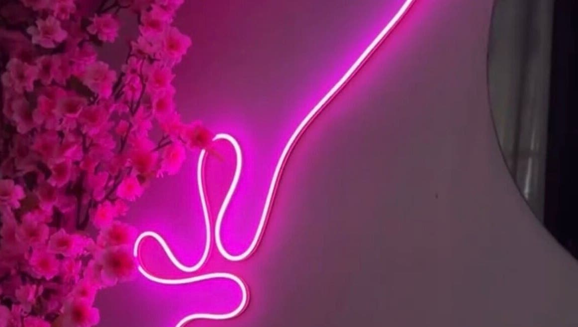 Neón rosa y flores decoran el ambiente acogedor de Pink Beauty Studio en San Juan, PR.