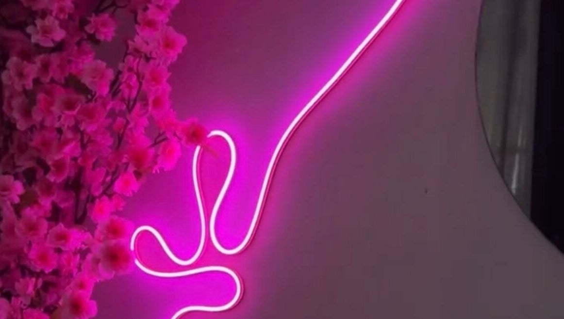 Neón rosa y flores decoran el ambiente acogedor de Pink Beauty Studio en San Juan, PR.