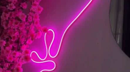 Neón rosa y flores decoran el ambiente acogedor de Pink Beauty Studio en San Juan, PR.