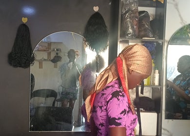 Pink Flame Beauty Salon, Lekki, Lagos, NG: Woman getting hair styled in cozy salon setting.