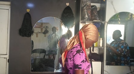 Pink Flame Beauty Salon, Lekki, Lagos, NG: Woman getting hair styled in cozy salon setting.
