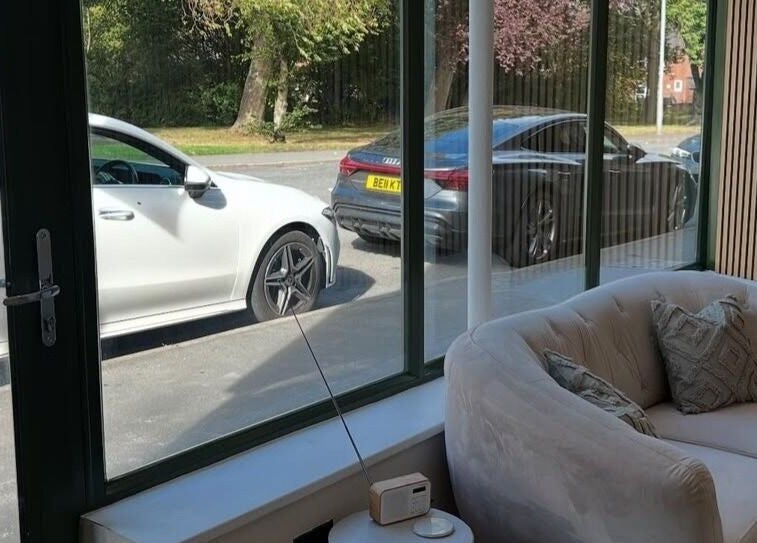 Cozy lounge area at Pro Brows.Studio in Normanton, England, GB with view of parked cars and greenery outside.
