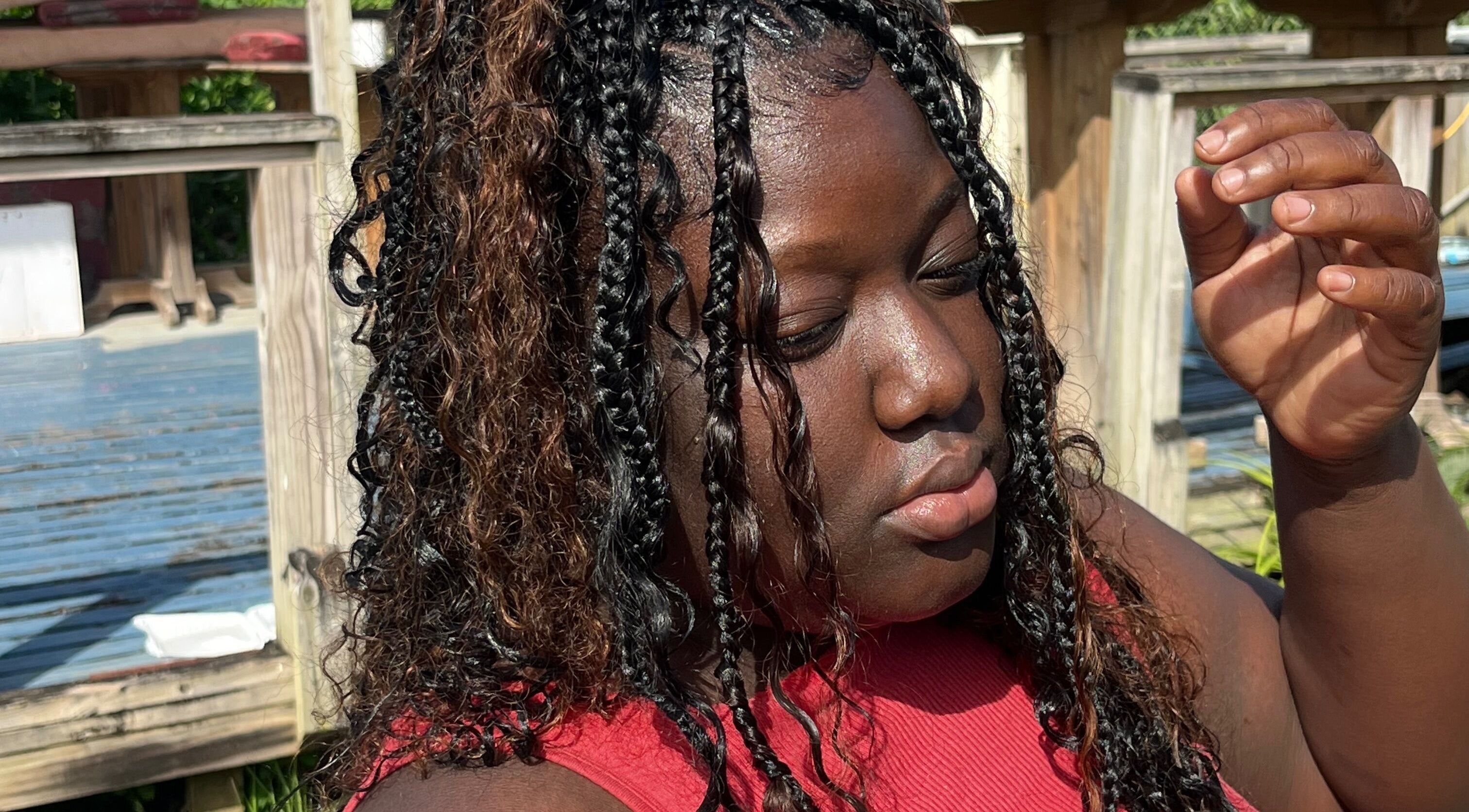 Woman with styled braids enjoying sun at Trendsetta Houseof Hair, Portsmouth, Saint John Parish, DM.