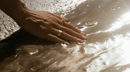 Main touchant délicatement l'eau à Maison Sanaa – Institut / Facial Studio à Toulouse, Occitanie, FR.