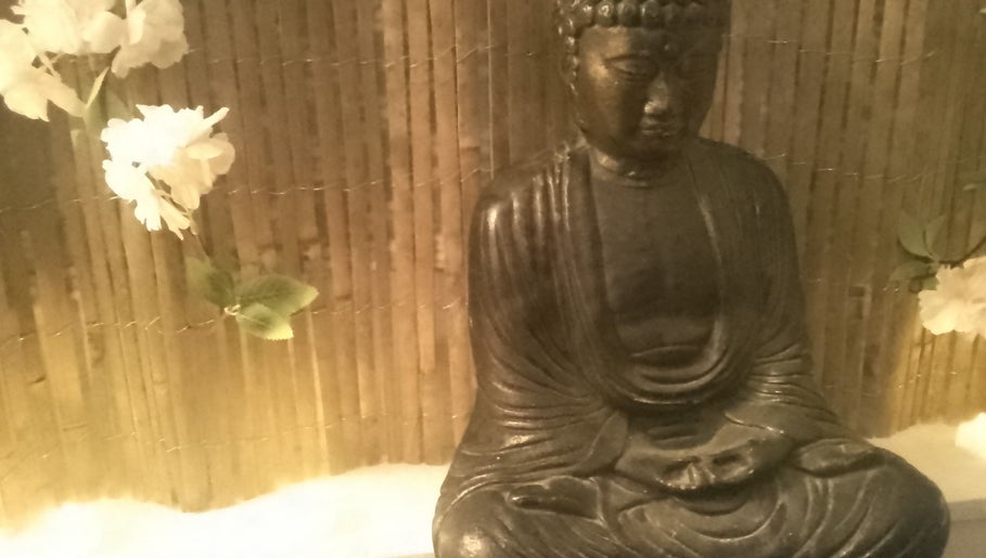 Buddha statue with flowers at Hands Of Nature, Kineton, England, GB.