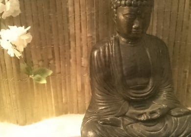 Buddha statue with flowers at Hands Of Nature, Kineton, England, GB.
