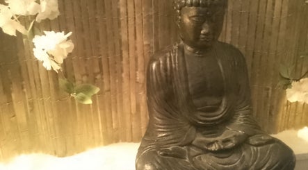 Buddha statue with flowers at Hands Of Nature, Kineton, England, GB.