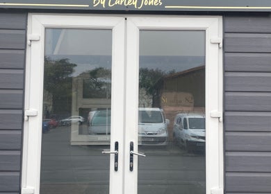 Entrance of JD’s beauty bar in Pontyclun, Wales, GB, showcasing modern glass doors.