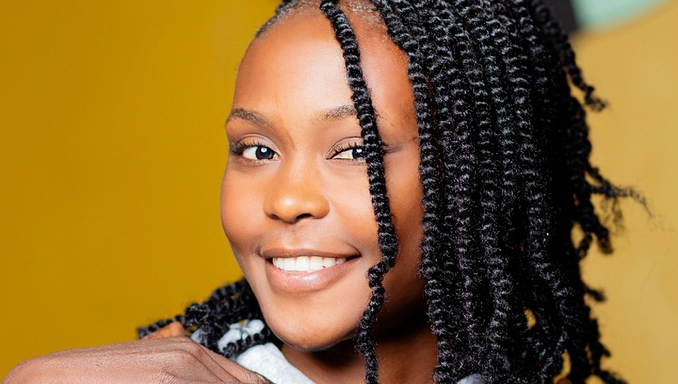 Smiling woman with styled curls at Natural Kurls Kitwe Branch in Kitwe, Copperbelt Province, ZM.