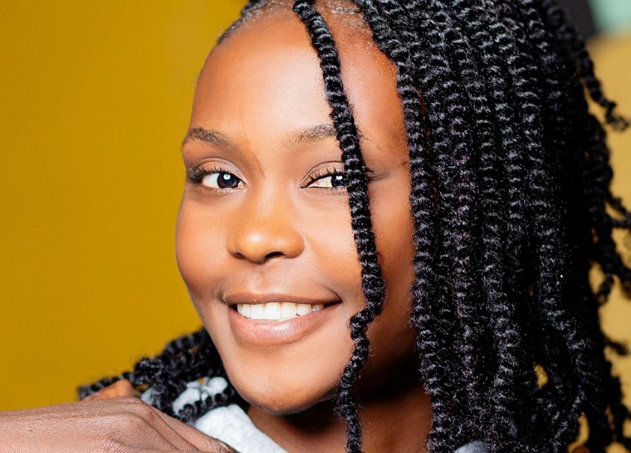 Smiling woman with styled curls at Natural Kurls Kitwe Branch in Kitwe, Copperbelt Province, ZM.