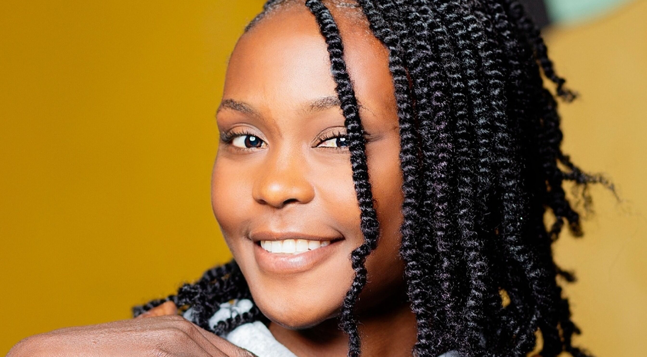 Smiling woman with styled curls at Natural Kurls Kitwe Branch in Kitwe, Copperbelt Province, ZM.