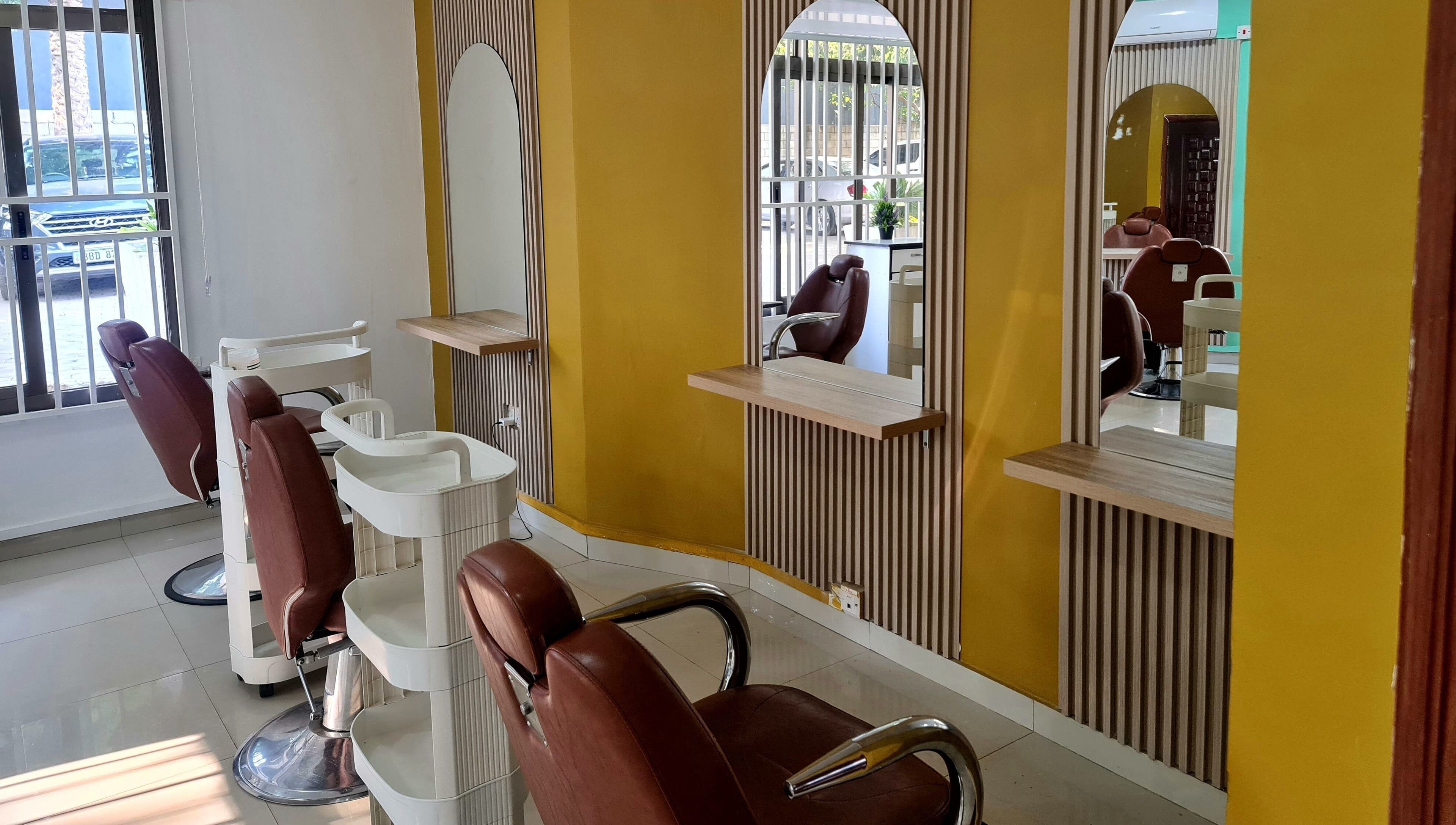 Modern salon interior at Natural Kurls Rhodespark Branch, Lusaka, ZM with stylish mirrors and chairs.