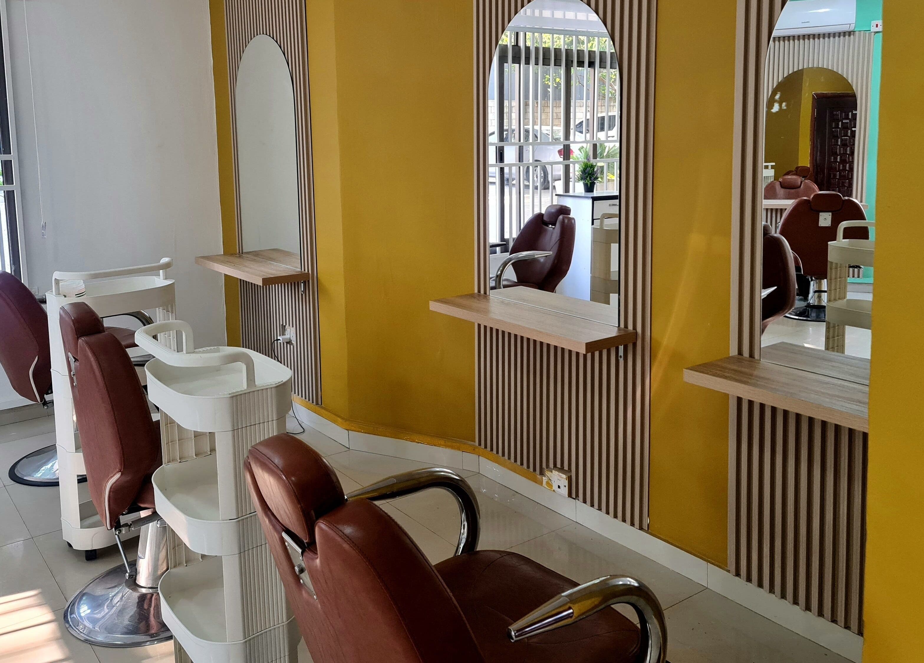 Modern salon interior at Natural Kurls Rhodespark Branch, Lusaka, ZM with stylish mirrors and chairs.