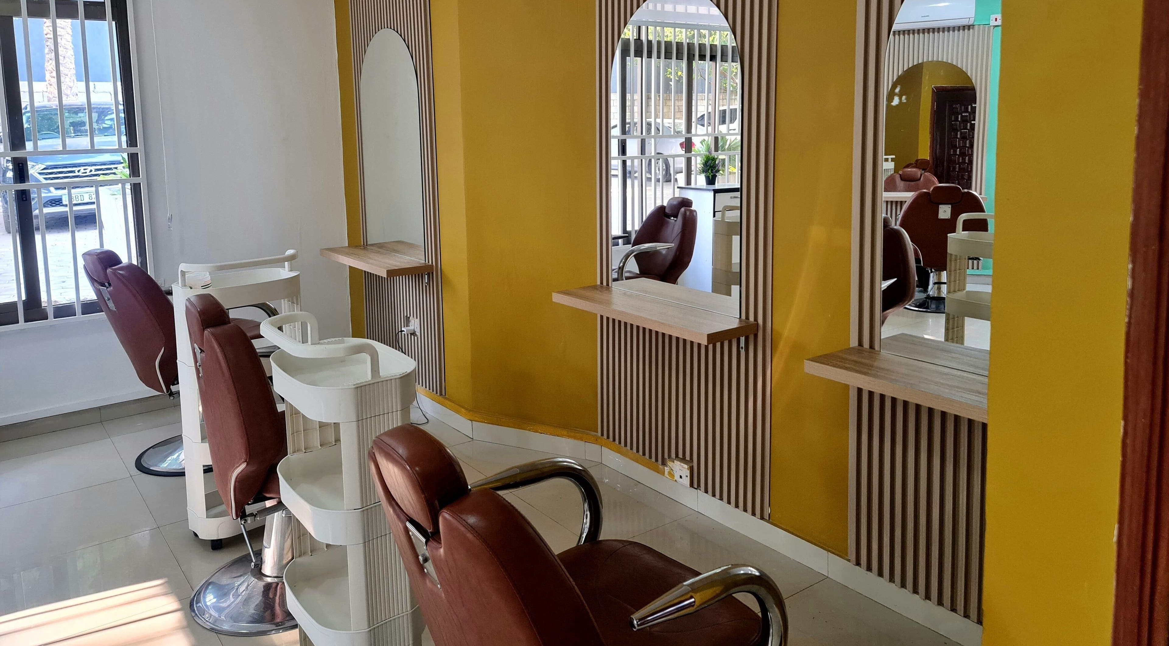 Modern salon interior at Natural Kurls Rhodespark Branch, Lusaka, ZM with stylish mirrors and chairs.