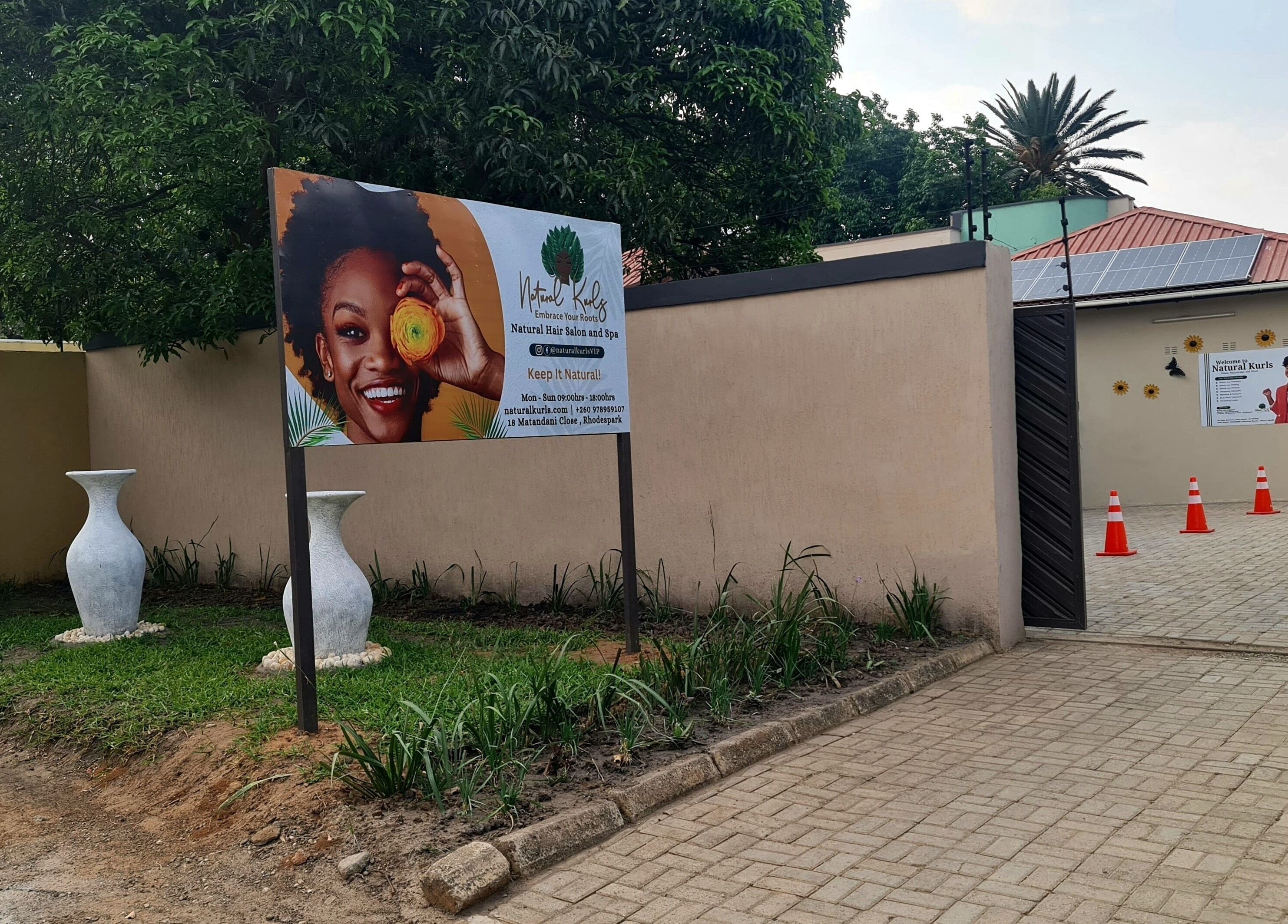 Entrance of Natural Kurls Rhodespark Branch in Lusaka, ZM, showcasing vibrant signage and modern decor.
