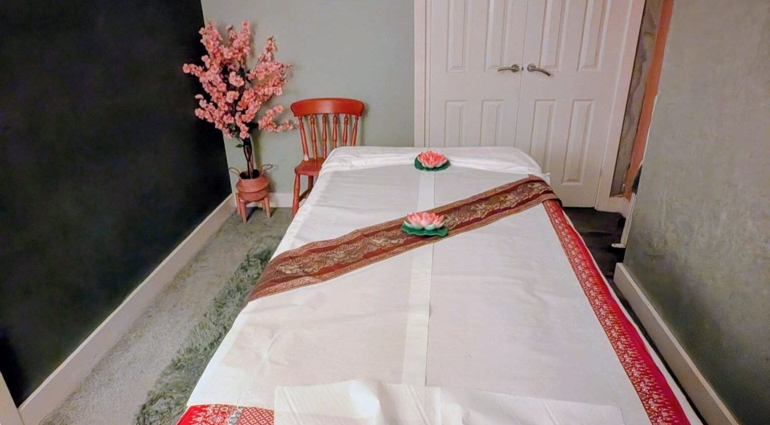 Tranquil massage room at Orchid Thai massage beauty and spa, Kidsgrove, England, GB, featuring a decorated table.