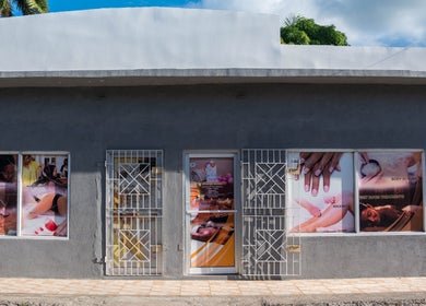 Front view of Escape To Exhale Day Spa at St. James Parish, showcasing beauty services with vivid window displays.