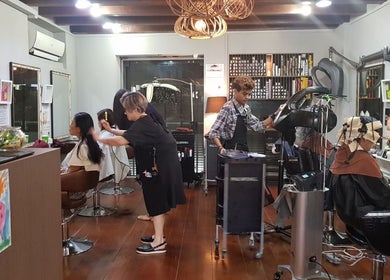 Stylists working at Su-a Hair Studio, Singapore, SG, creating elegant hairstyles for clients in a modern space.