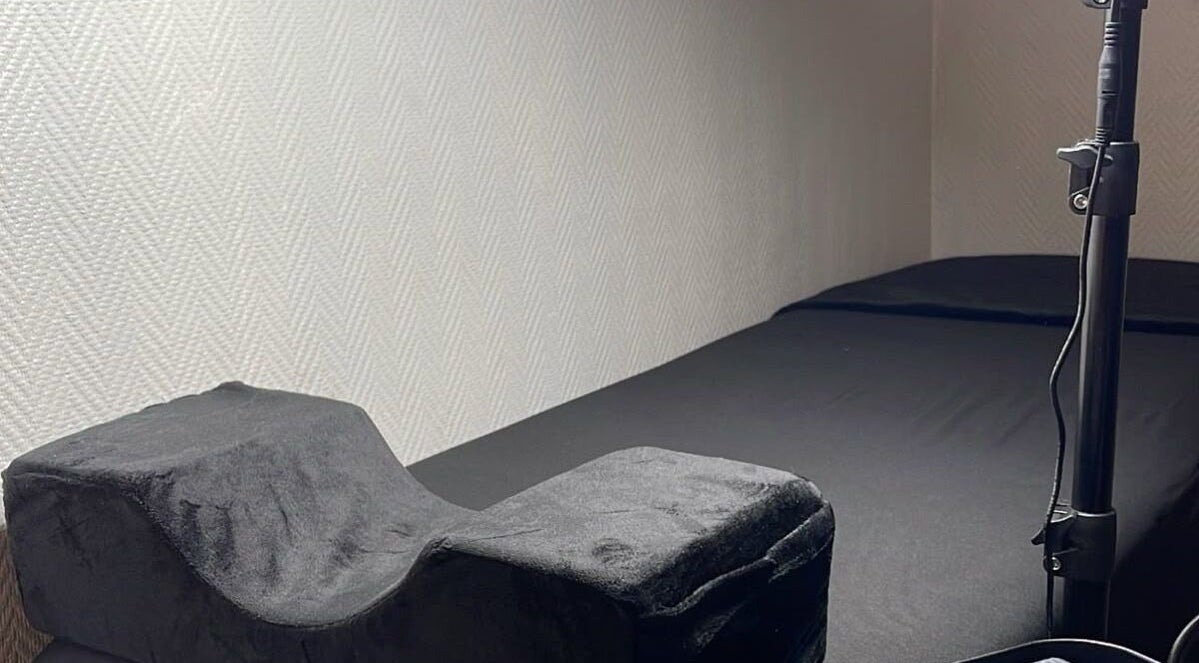 Cama de tratamientos en Nova Beautyy, Cali, Valle Del Cauca, CO, con almohada ergonómica negra.