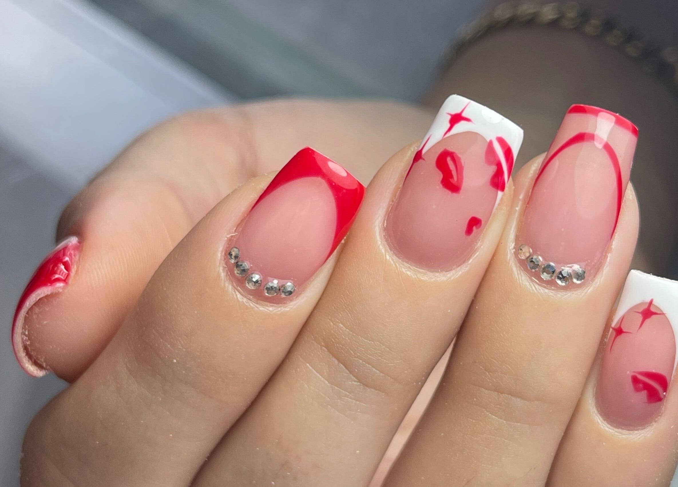 Diseño de uñas con detalles rojos y piedras en Nova Beautyy, Cali, Valle Del Cauca, CO.