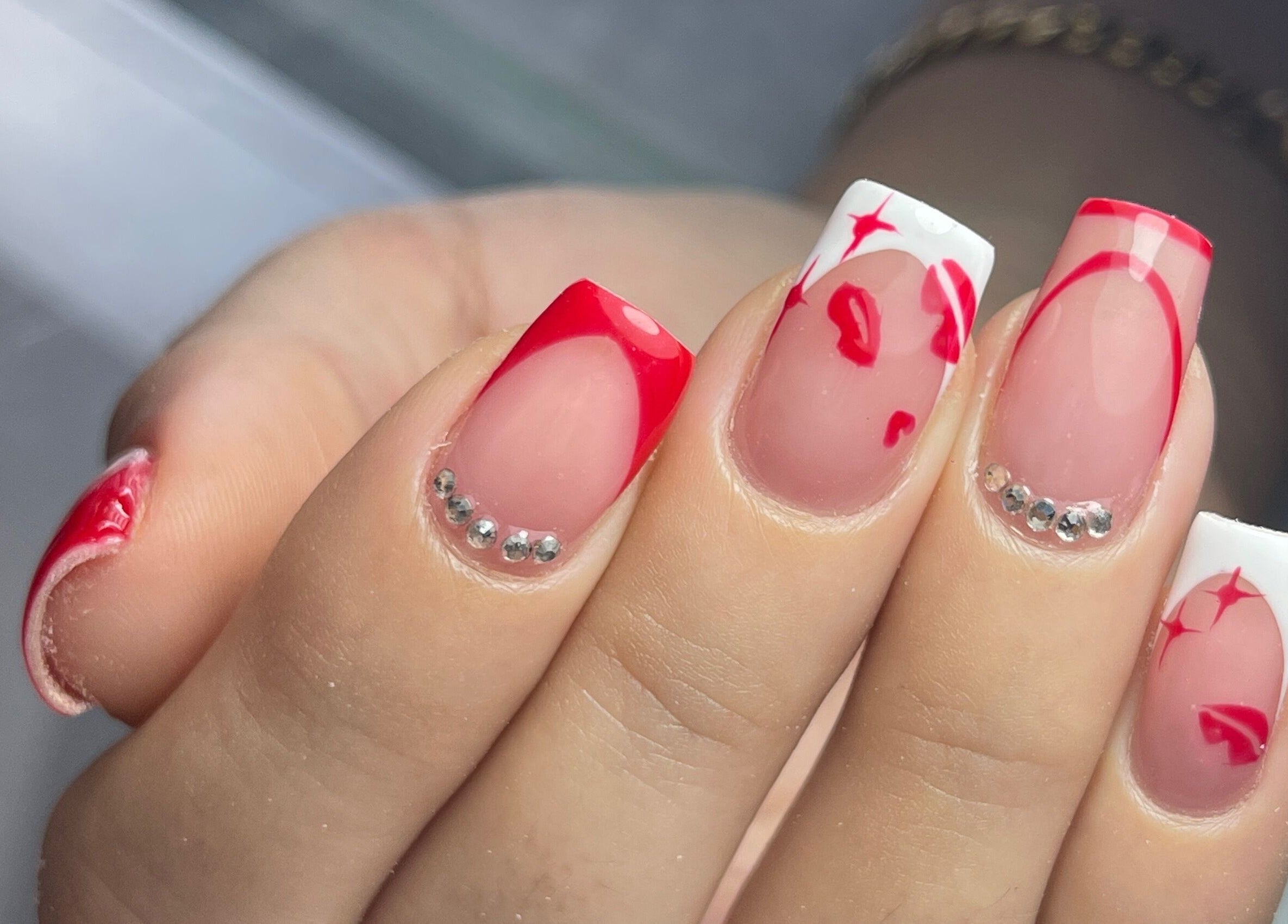 Diseño de uñas con detalles rojos y piedras en Nova Beautyy, Cali, Valle Del Cauca, CO.