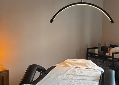 Serene treatment room at Formè, Evesham, England, GB, featuring a massage table with ambient lighting.