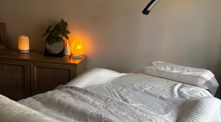 Tranquil massage room at Formè, Evesham, England, GB with cozy bed and soft lighting.