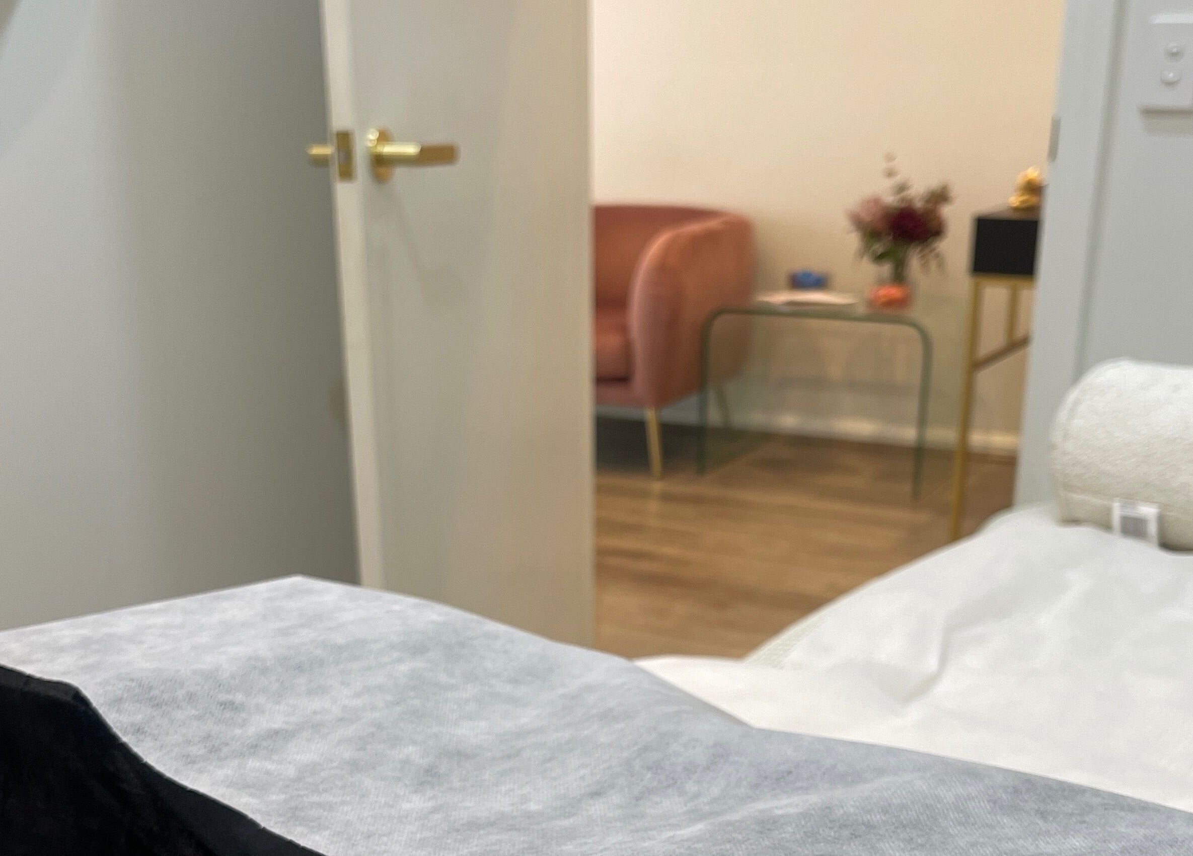 Relaxing treatment room at Sydney Lashess by Nicky in Manly, New South Wales, AU, showcasing cozy armchair and table.