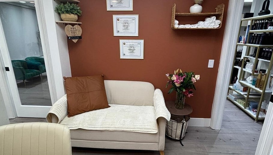 Sala de espera aconchegante do Essence Nails Studio em COCONUT CREEK, US, com sofá e decoração acolhedora.