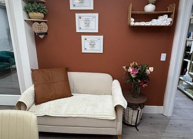 Sala de espera aconchegante na Essence Nails Studio, Coconut Creek, Florida, com decoração elegante e quadros na parede.