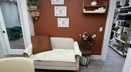 Sala de espera aconchegante na Essence Nails Studio, Coconut Creek, Florida, com decoração elegante e quadros na parede.