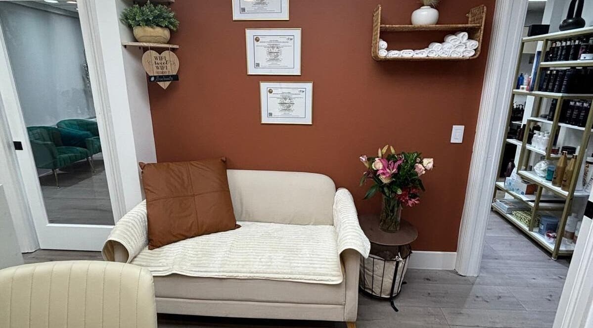 Sala de espera aconchegante na Essence Nails Studio, Coconut Creek, Florida, com decoração elegante e quadros na parede.