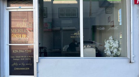 Fachada de Merlina Nails en San Francisco De Macorís, Duarte, DO, con decoración floral y horario visible.