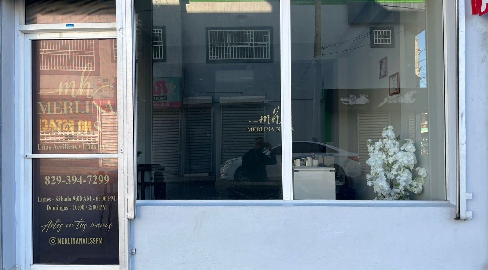 Fachada de Merlina Nails en San Francisco De Macorís, Duarte, DO, con decoración floral y horario visible.