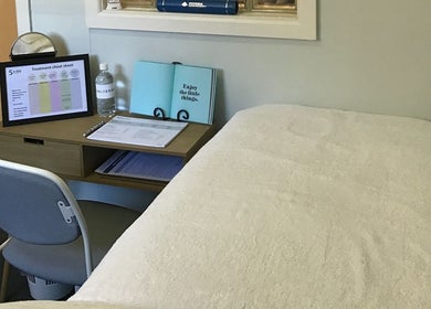 Cozy treatment room at The GLOW UP Clinic (Brisbane) in Kangaroo Point, Queensland, AU with a comfortable chair and desk.