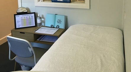 Cozy treatment room at The GLOW UP Clinic (Brisbane) in Kangaroo Point, Queensland, AU with a comfortable chair and desk.