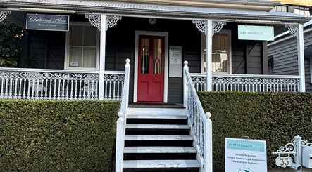 The GLOW UP Clinic (Brisbane) at Kangaroo Point, Queensland, AU features a quaint facade with intricate white railings.