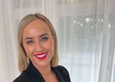 Woman smiling warmly at The GLOW UP Clinic (Elsternwick), Melbourne, Victoria, AU.