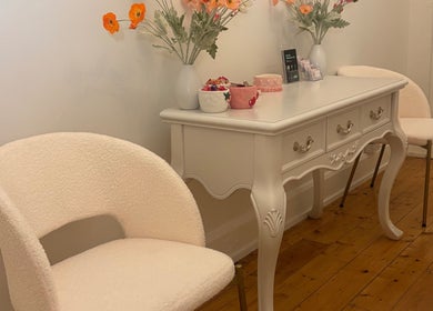 Chic seating area at The GLOW UP Clinic (Elsternwick), Melbourne, Victoria, AU with plush chairs and floral decor.