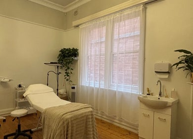 Relaxing treatment room at The GLOW UP Clinic (Elsternwick), Melbourne, Victoria, AU with cozy bed and plants.
